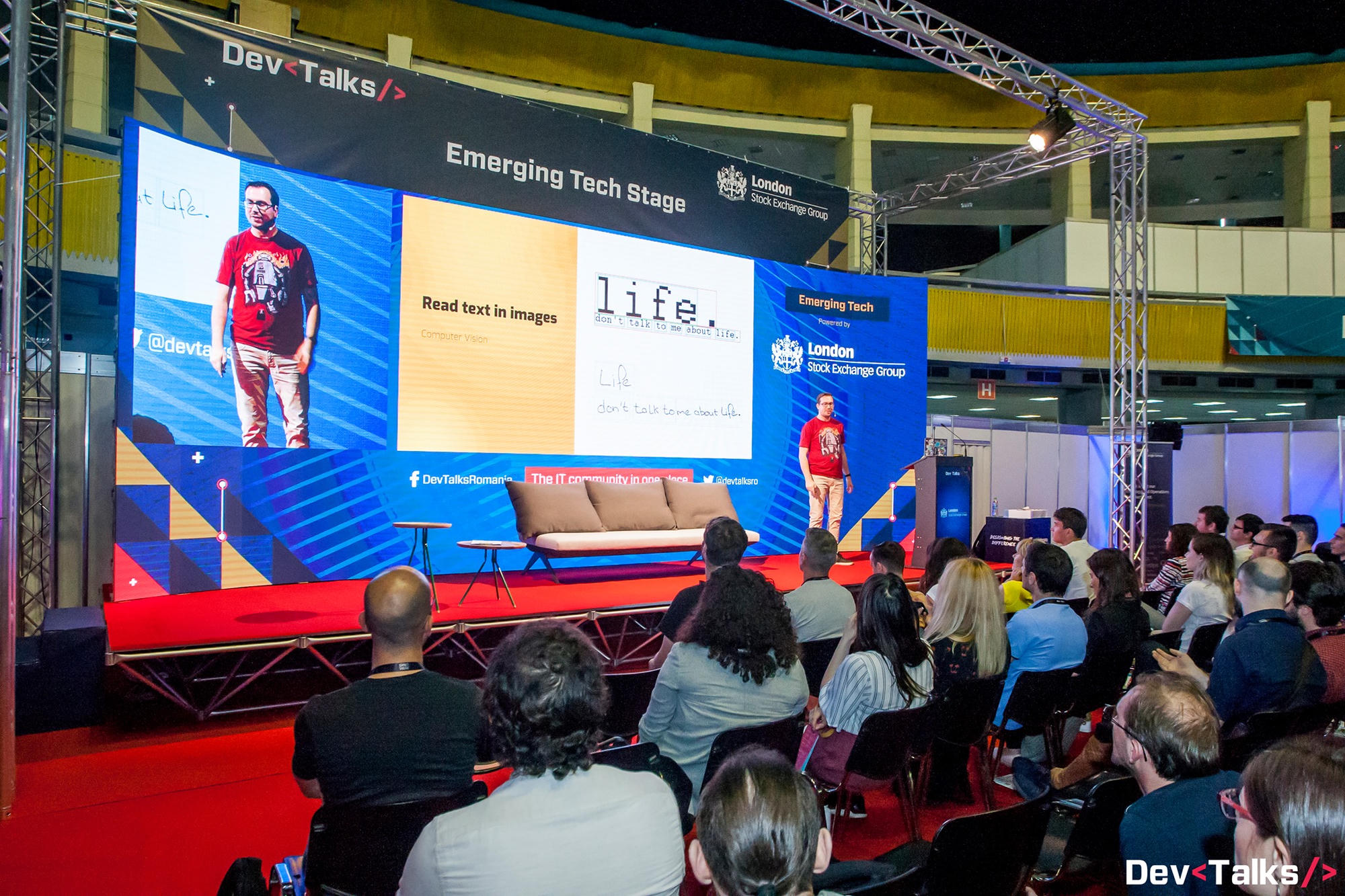 A large conference stage seen from the back of a packed audience, every seat taken, my slide about reading text in images filling the screen behind me