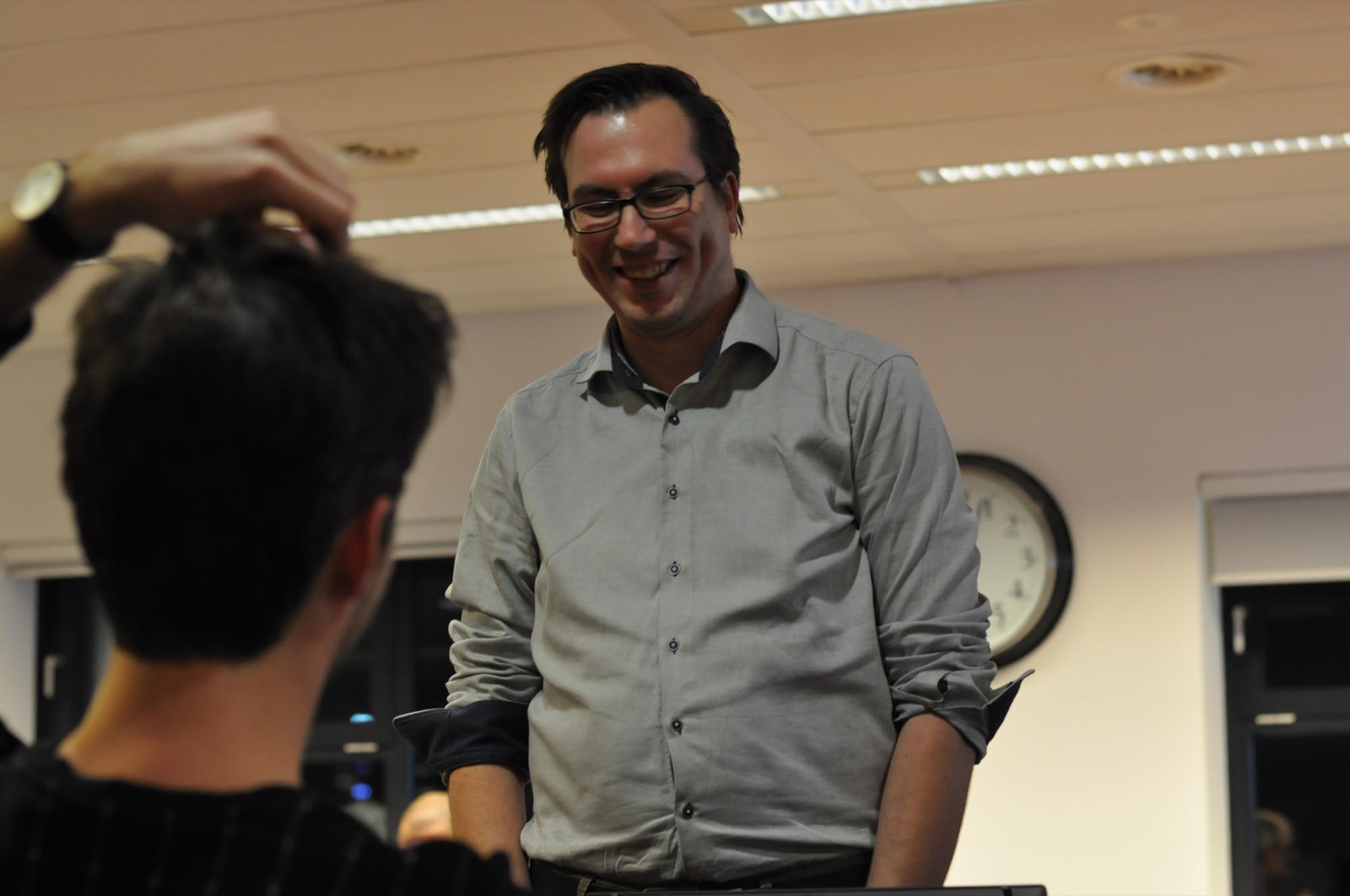 Laughing with an attendee at the front of the room after a meetup talk